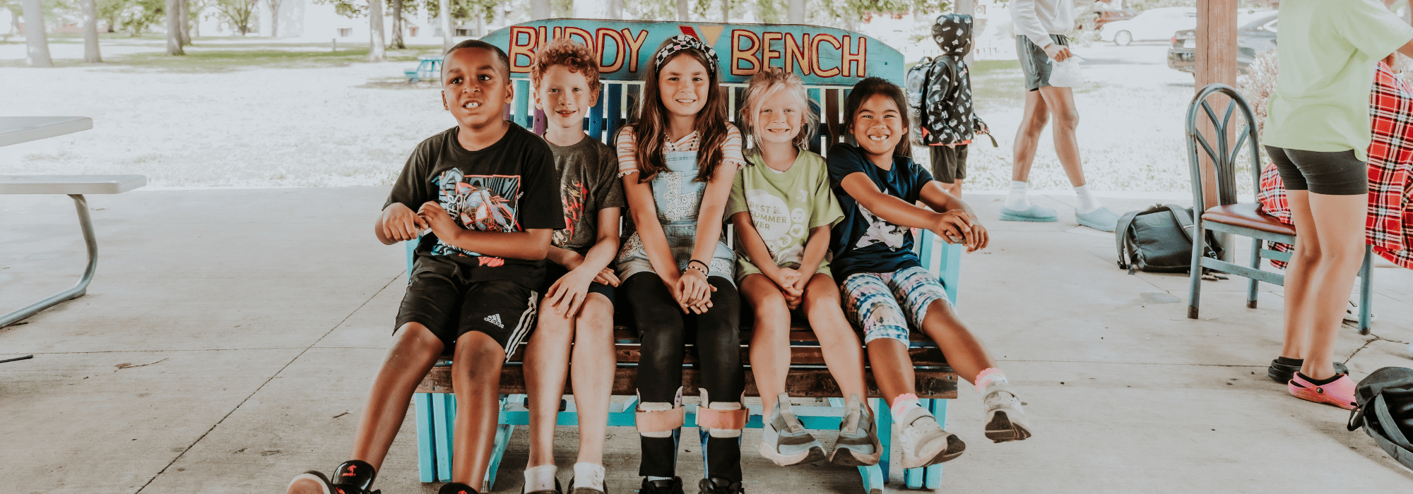 School age children sitting on a buddy bench