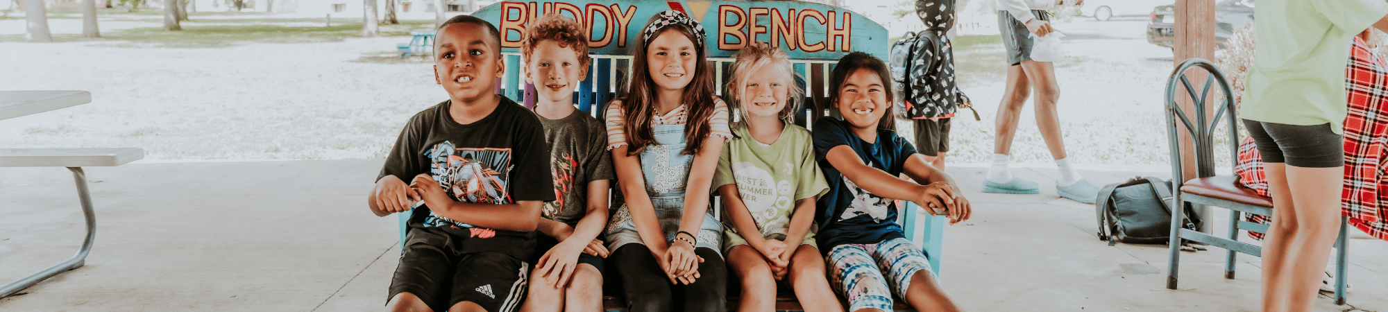 school age care students sitting together on a bench