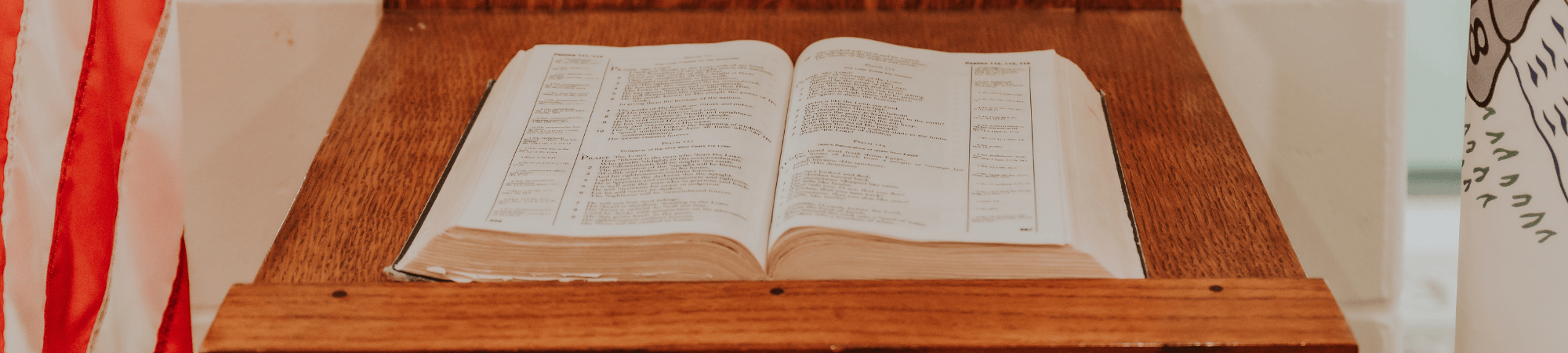 a bible on a stand with an american flag on the left side