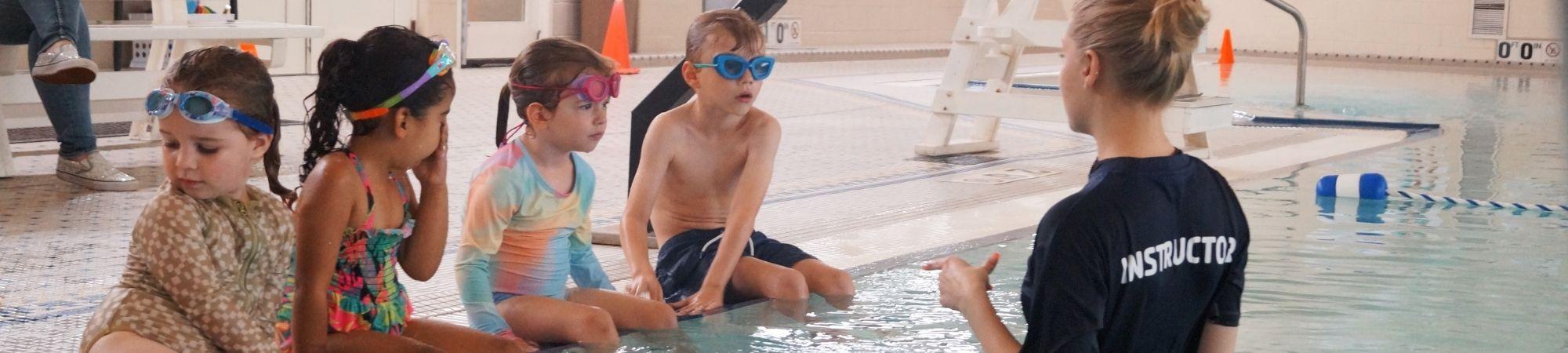 Instructor teaching multiple kids in swim lessons