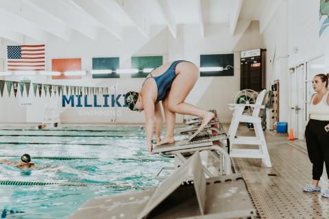 swimmer practices diving from the starting blocks